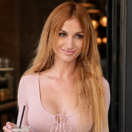 Bamby Doll holding an iced drink in a casual bold side portrait